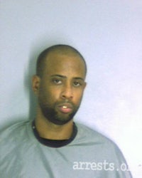 a man in a gray shirt is posing for a mugshot
